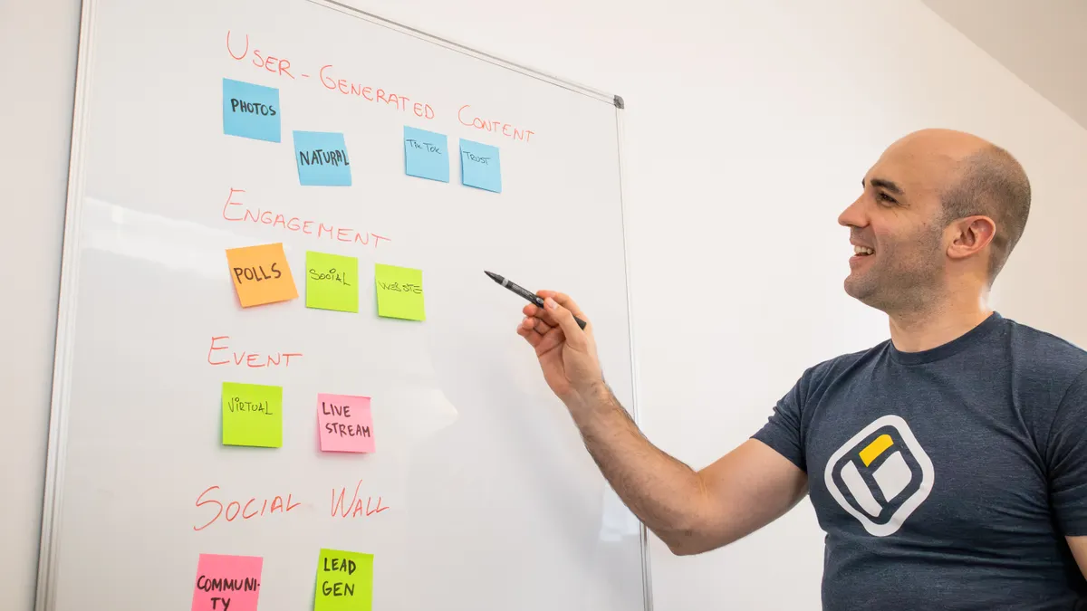 Person pointing at a sticky-note content planning board