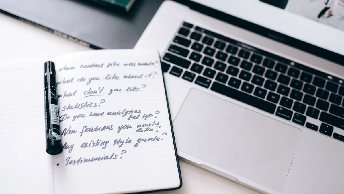 open notebook with content strategy notes beside a laptop