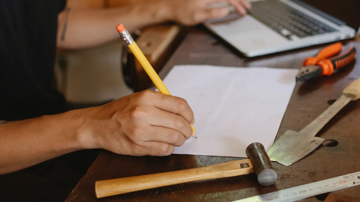 Content writing tools with built-in SEO features: which to pick for optimization — Crop artisan writing on paper and typ