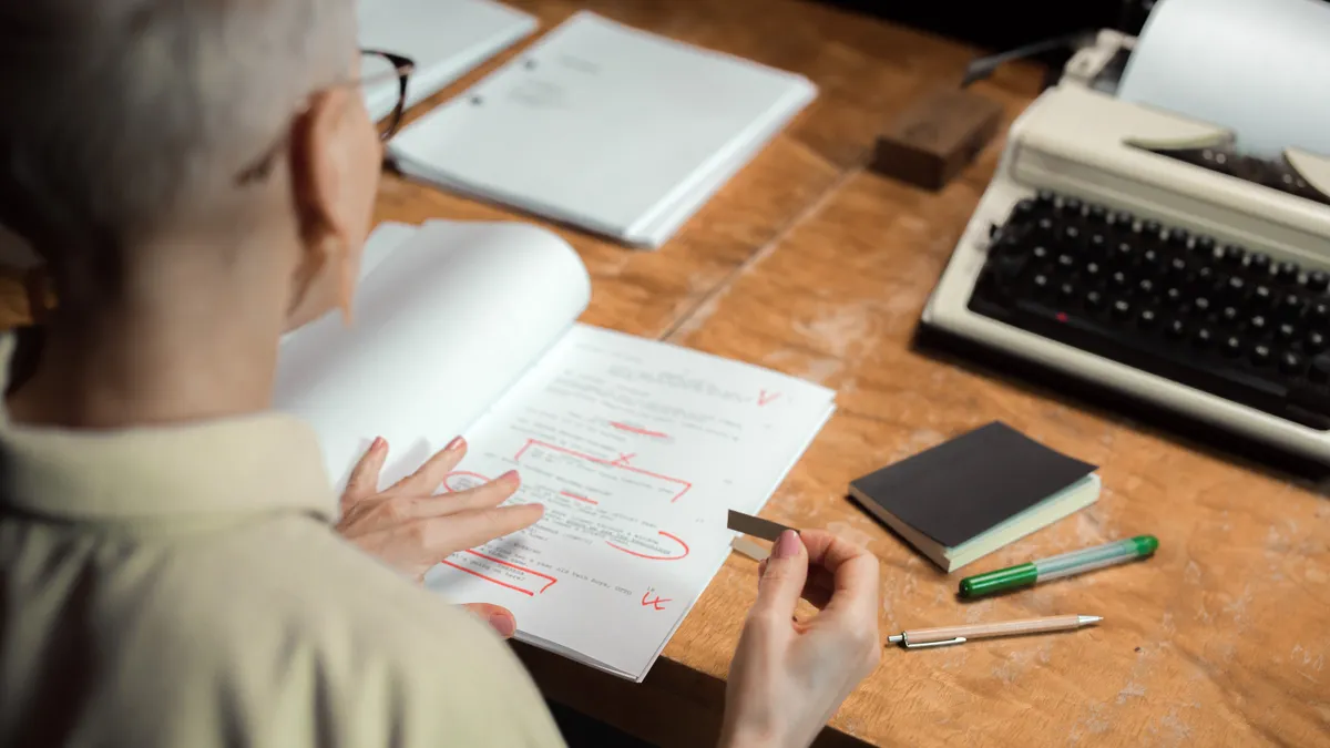 Editor marking a manuscript with red corrections