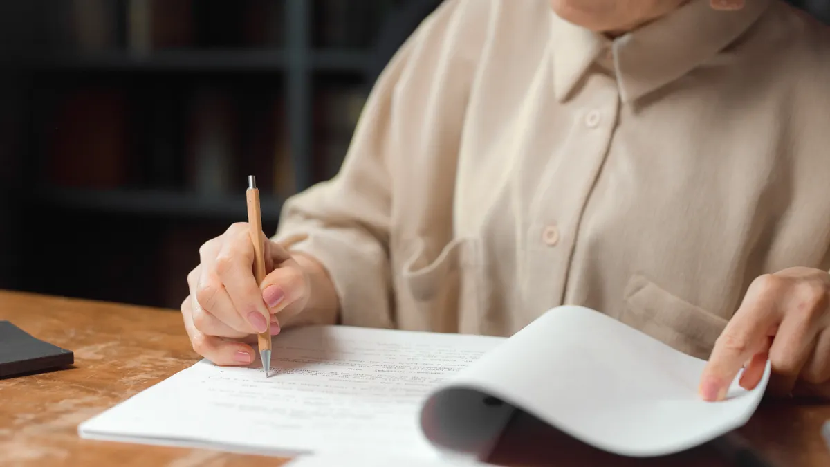Person proofreading a document at a desk