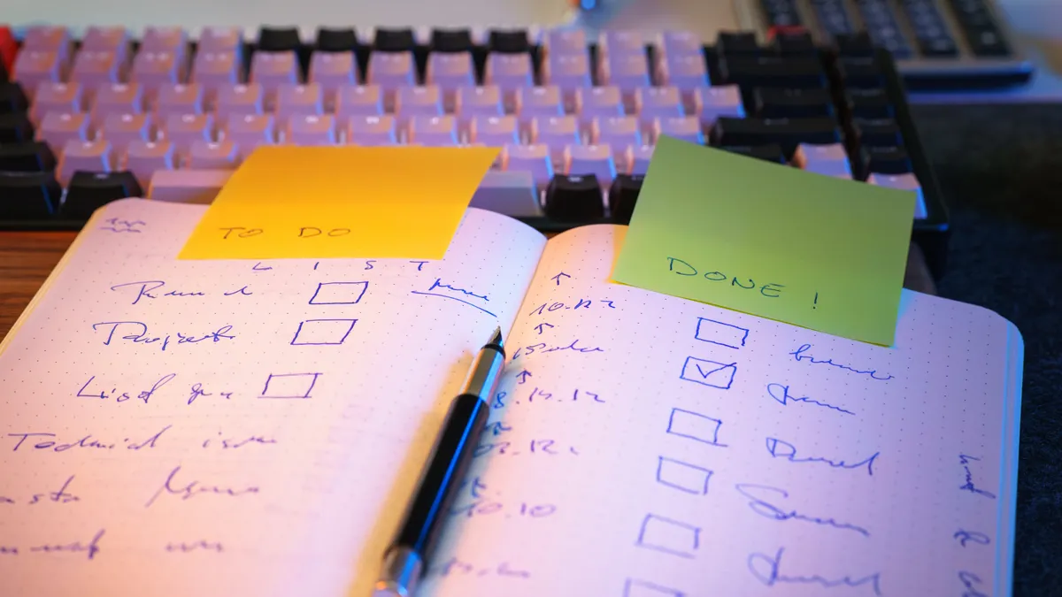 How to build an AI content review checklist Open notebook checklist beside a keyboard and sticky notes